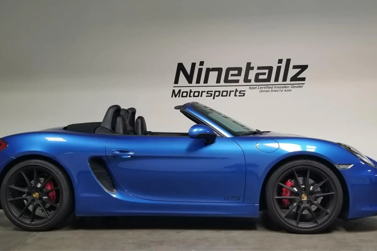 Blue Porsche Boxster GTS in showroom